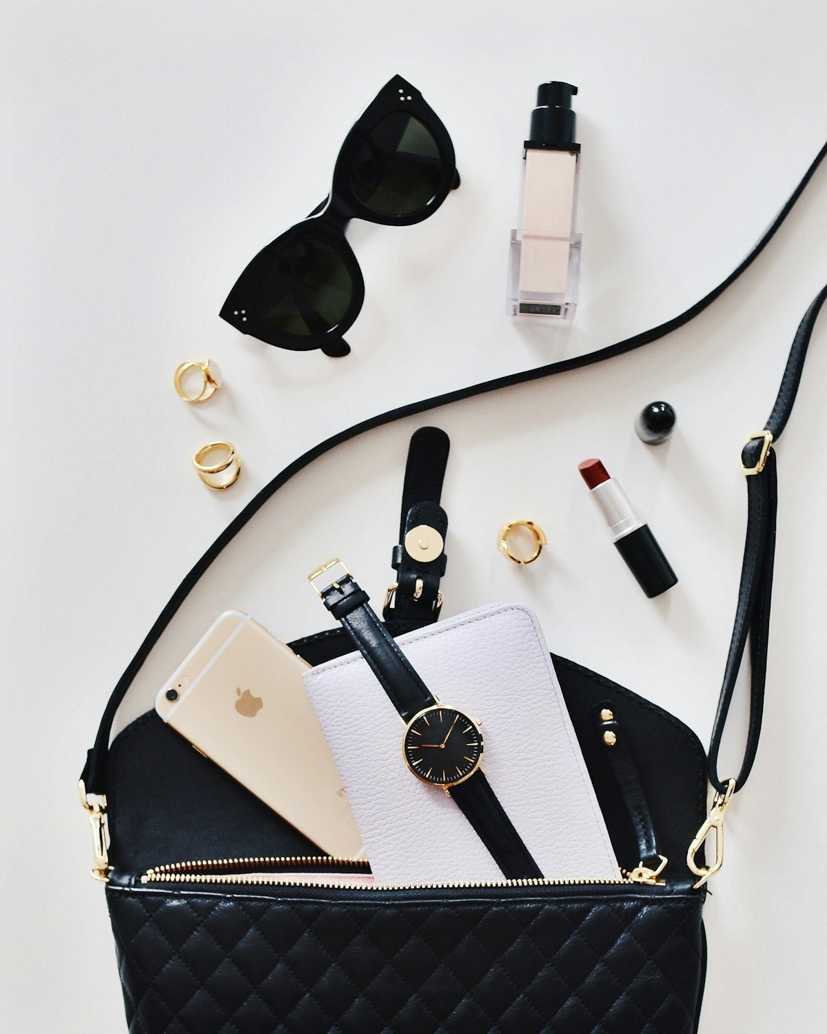 Styled flat lay of sunglasses, watches and accessories on a white surface