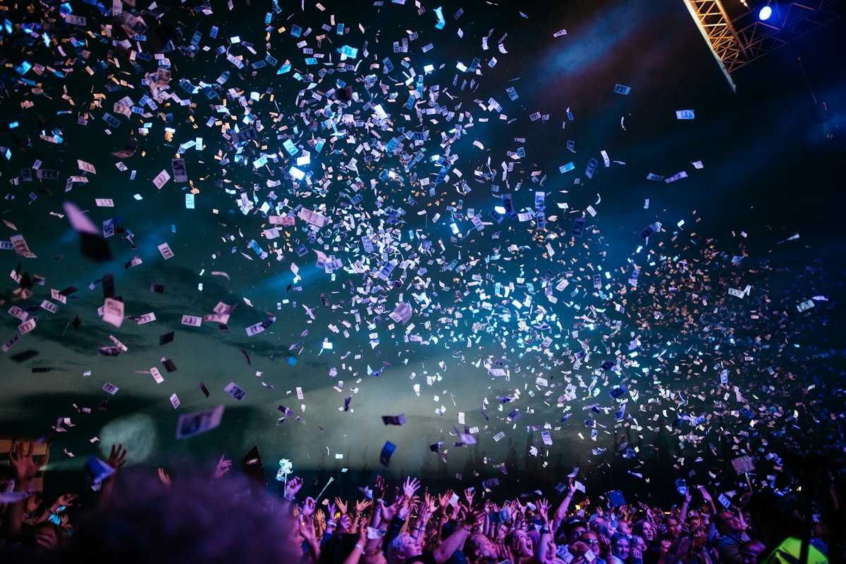 Confetti bursting over a cheering crowd at a live event