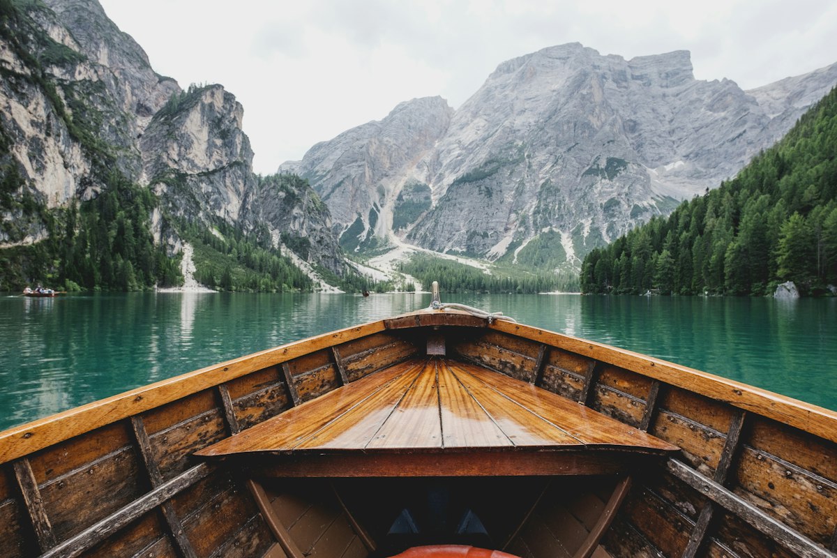 Wooden boat on a turquoise alpine lake surrounded by mountains